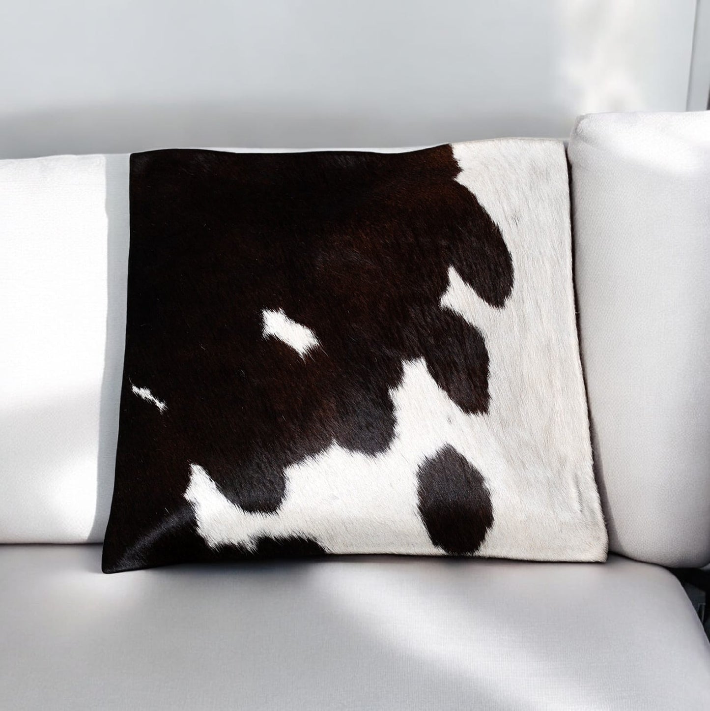Cow print pillow on a white sofa
